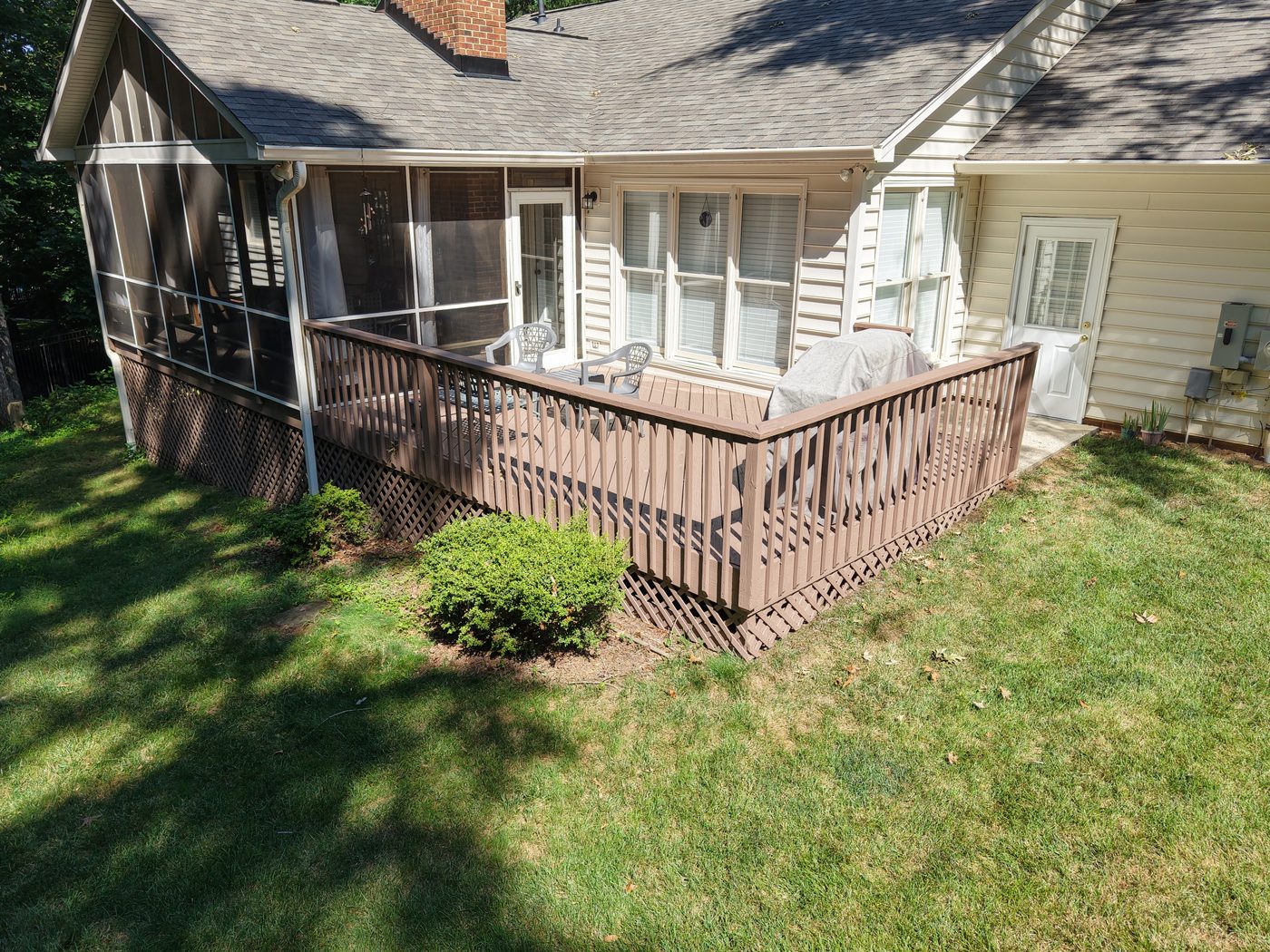 Stained wood deck with railing and screened porch on a Charlotte, NC home