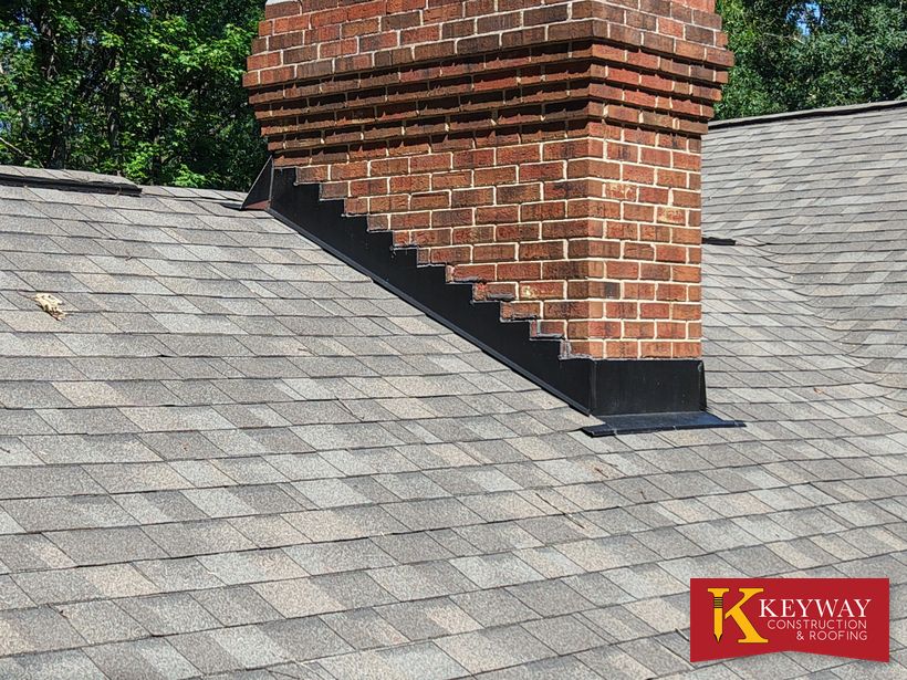Close-up of new chimney step flashing and roof-edge repair in Charlotte, NC