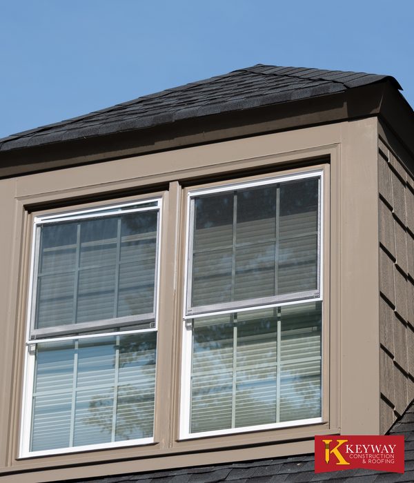 Repaired roof dormer on a Charlotte area home with new corner trim, shake style siding and double hung windows