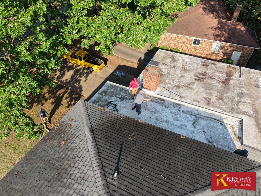 Stained flat roof section and worn shingles on a Charlotte NC home before replacement