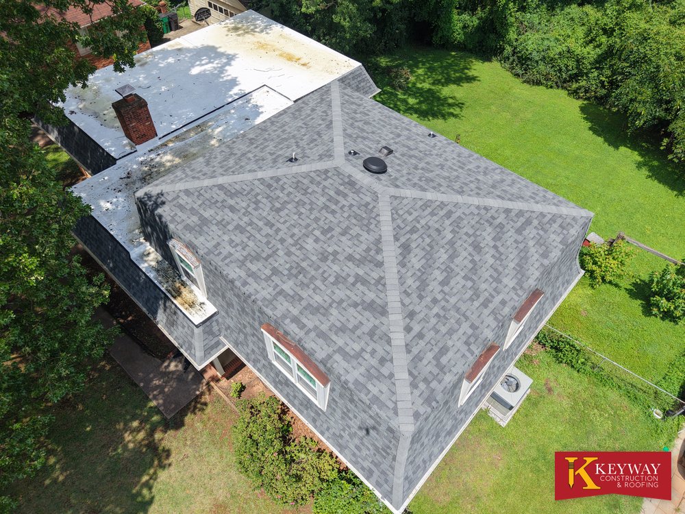 Drone view of a Charlotte NC home with new shingles and bright white flat roof sections