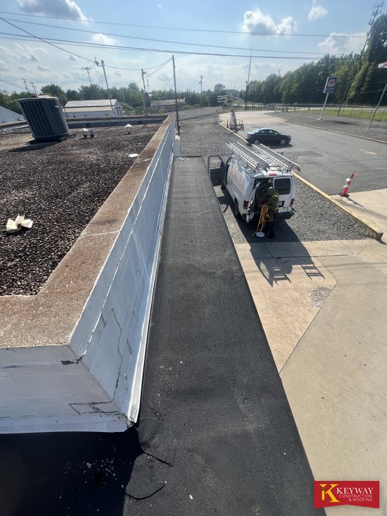 Finished commercial roof parapet with new membrane running along the roof edge