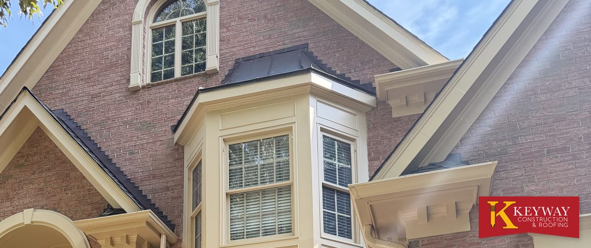 Cornice returns, rake trim and a bay window roof on a large brick home in Charlotte, the kind of eave detail common around Lake Norman