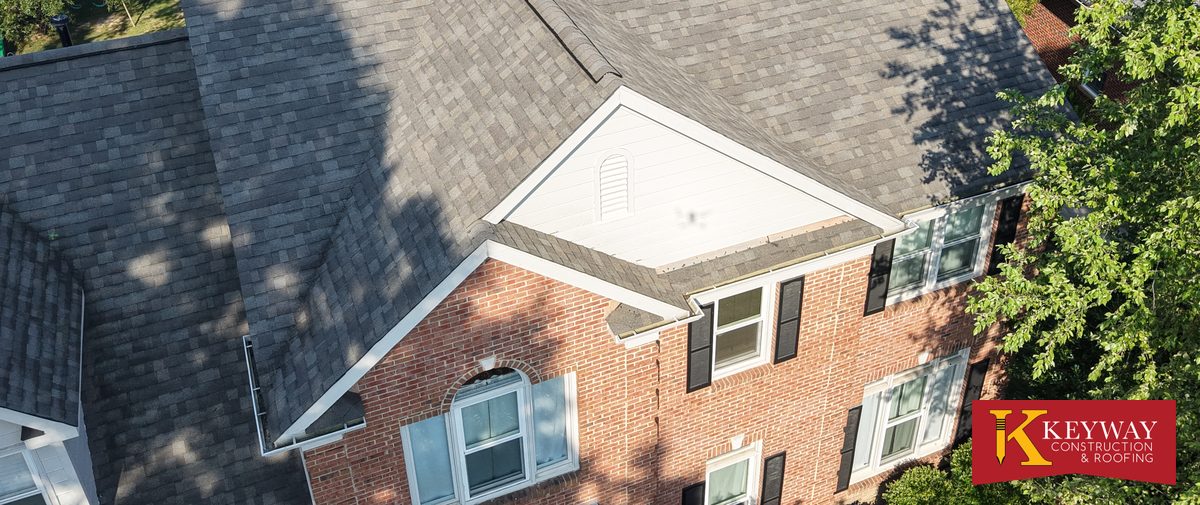 Drone view of a brick Matthews NC home showing white rake trim, fascia and the gutter line after a Keyway re-roof